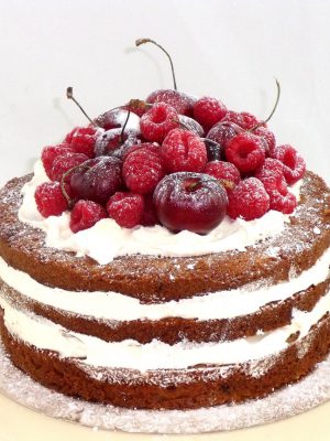 tarta con bizcochos desnudos rellenos de buttercream, adornada con frutas naturales