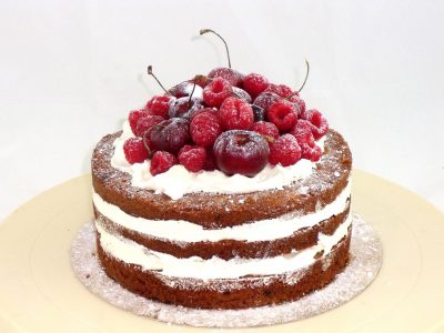 tarta con bizcochos desnudos rellenos de buttercream, adornada con frutas naturales