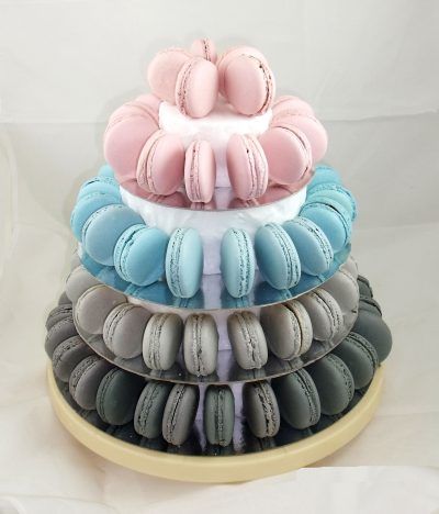Macarons de diferentes colores y sabores colocados en un soporte de madera en forma de torre.