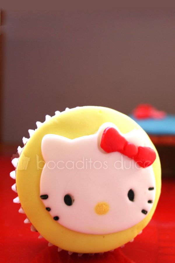 Cupcakes decorado con un circulo de fondant que a su vez esta decorado con la cara de la gatita Kitty.