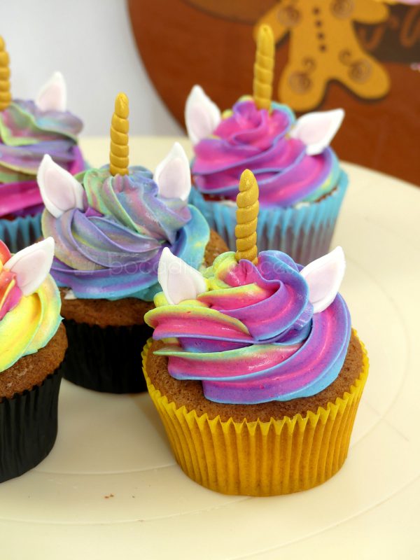 Cupcakes de chocolate, decorado con una buttercream de diferntes colores y a su vez con unas orejitas y un cuerno que hacen que parezca un Unicornio.