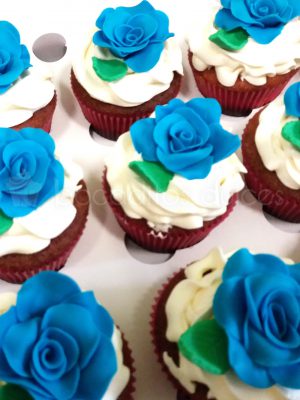 Cupcake clasico decorado con una rosa de fondant azul.