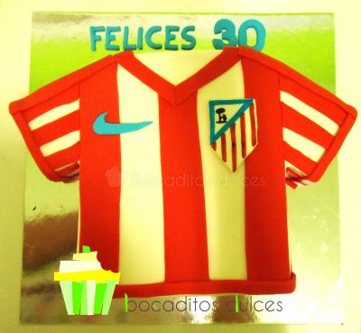 Tarta tallada con forma de camiseta del equipo de futbol del atletico de madrid.