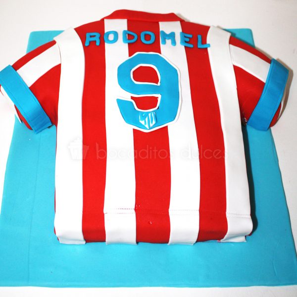 Tarta tallada con forma de camiseta del equipo de futbol del atletico de madrid.