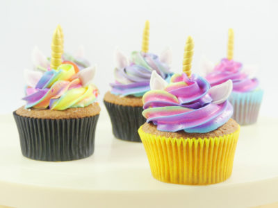 Cupcakes de vainilla, decorados con butterceam multicolor de vainilla y decorados con unas pequeñas orejas de color blanco y un pequeño cuerno dorado de fondant.
