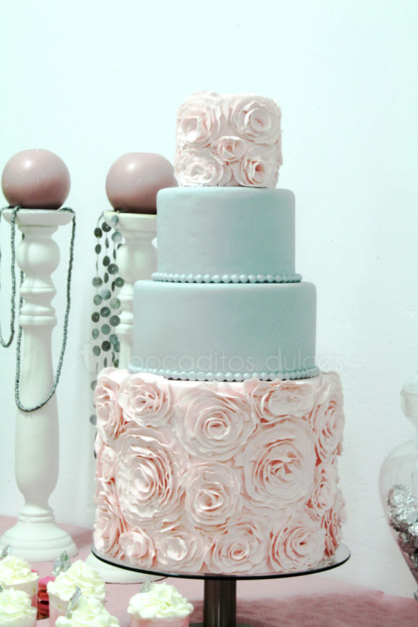 Mesa compuesta por cake pops, variesad de gominolas, nini pastelitos, vasitos con batidos de fresa y nata, macarons, cupcakes y tarta personalizada de cuatrao pisos