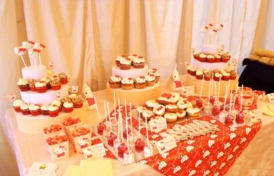Mesa compuesta por cake pops, cup cake y mini cupcakes, distintos tipos de gominola, cake pops, donuts, chocolatinas y palomitas.