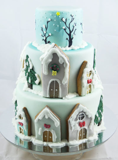 tarta de fondant con decoración pintada con aerógrafo, árboles nevados y casitas de galleta
