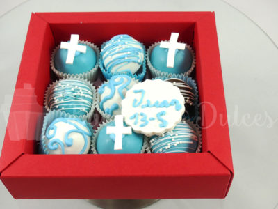 cajita con cake balls en blancos y azules y placa de choco