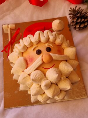 piñata de papa noel de chocolate blanco decorada con nubes y rellena de chocolates y bombones