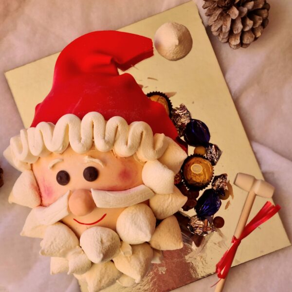piñata de papa noel de chocolate blanco decorada con nubes y rellena de chocolates y bombones