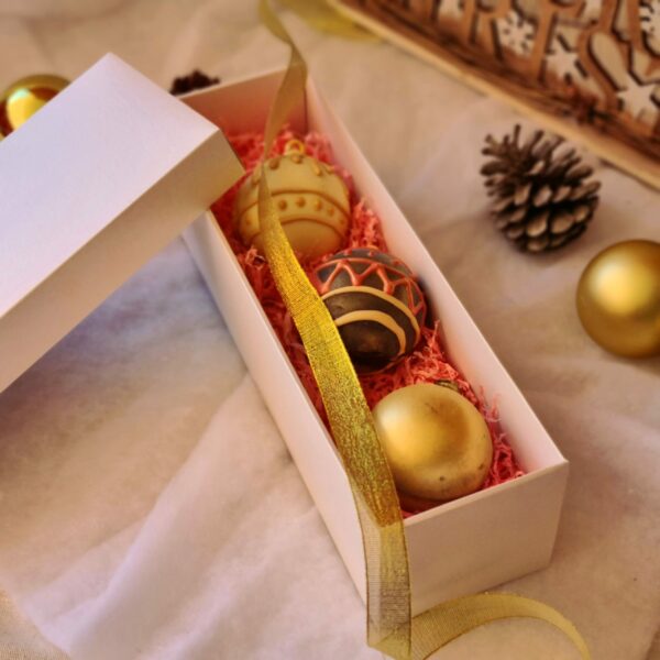 caja con 3 bombas de chocolate caliente con forma de bola de árbol
