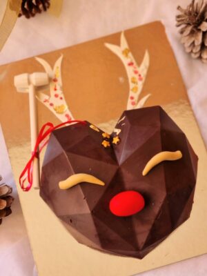 piñata de reno de chocolate decorada con nubes y rellena de chocolates y bombones