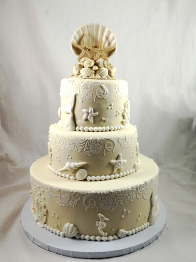 tarta de boda en color arena y con detalles de conchas,caracolas y estrellas de mar