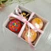 caja transparente con 4 macapops (macarons con palo y cobertura de chocolate)