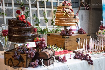 Tarta desnuda de tres pisos decorada con flores y frutos rojos, tarta de tres pisos cubiertos de chocolate negro decorada con frutos rojos, cupcakes, galletas tipo piruleta y cake pops