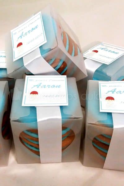 Caja de plastico con cinco galletas de mantequilla decoradas con fondant azul y en su extrior va decorada con etiqueta personalizada.