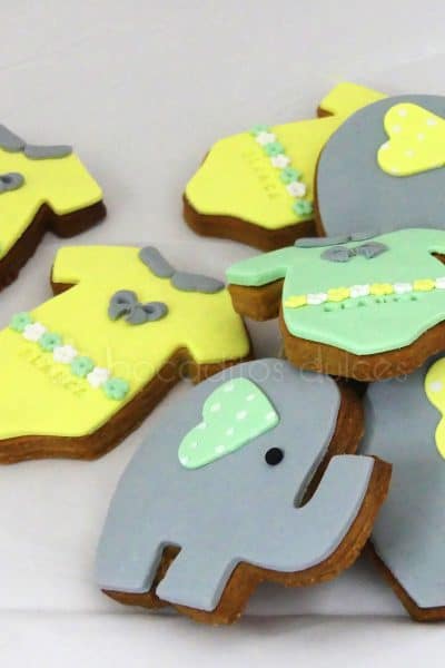 Galletas de mantequilla con forma de body de bebe decorado con fondant amarillo, galletas con forma de elefante decorado con fondant gris.