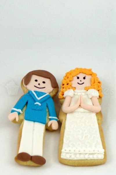 Galletas de mantequilla con forma de niño o niña vestidos con traje de comunión en fondant.