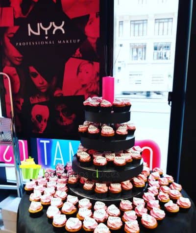 Cupcakes de vainilla, y buttercream de fresa colocados en un soporte de madera dando forma a una torre