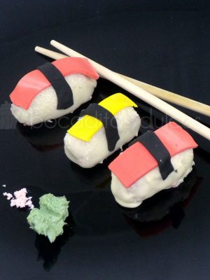 piezas de delicioso nigiri dulce. relleno de bizcocho con cobertura de chocolate y detalles en pasta de azúcar
