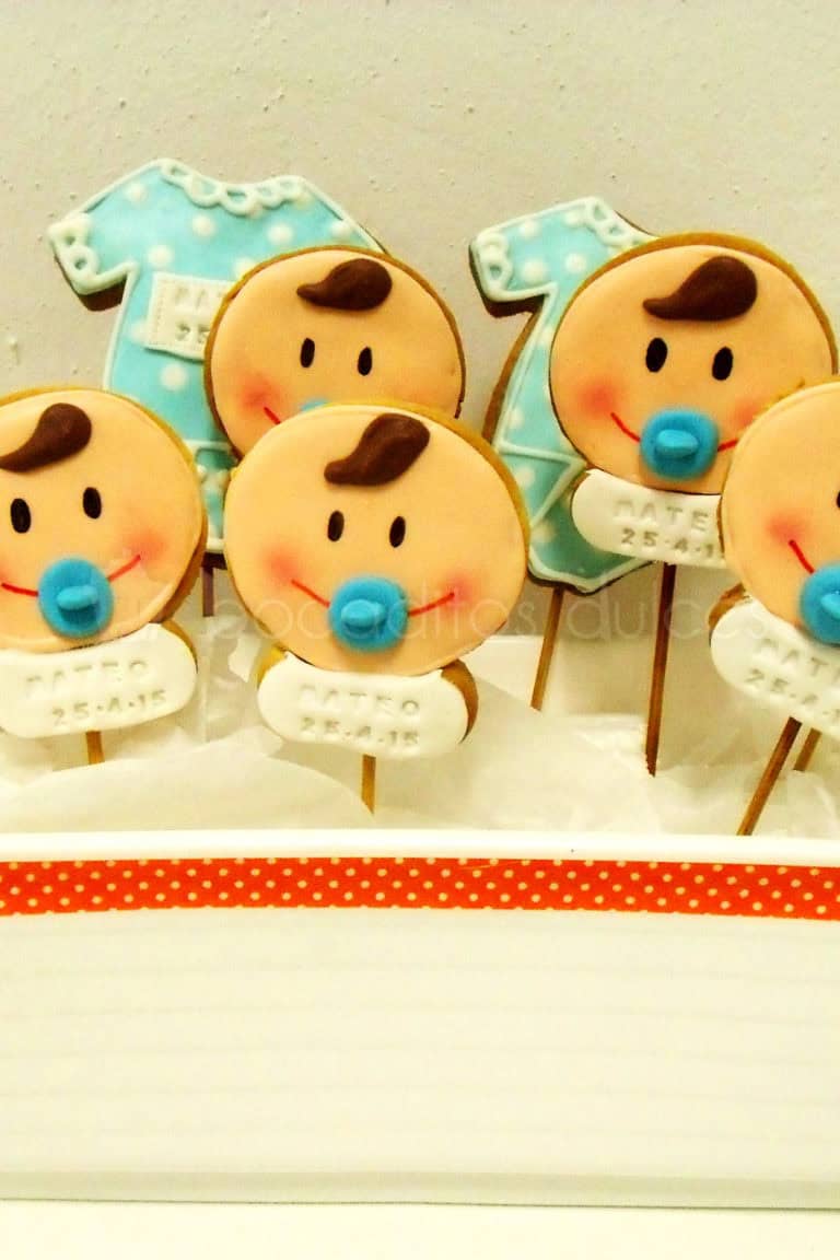 Galletas piruleta de fondant con la carita de un bebe, y bodys de bebe.
