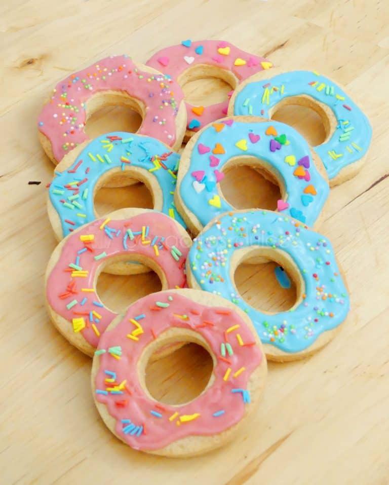 Galletas de mantequilla imitando las rosquillas de los simpson decoradas con glaseado de color rosa y azul y pequeñas virutas de colores