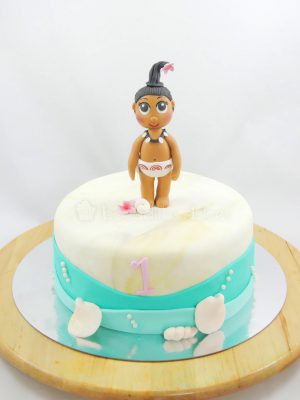 Tarta forrada con fondant blanco, y decorada alrededor con fondant azul emulando agua y pequeñas conchas en fondant y la protagonista de la pelicula en fondant.