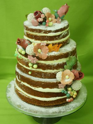 Tarta desnuda de tres pisos decorada con flores talladas en fondant.