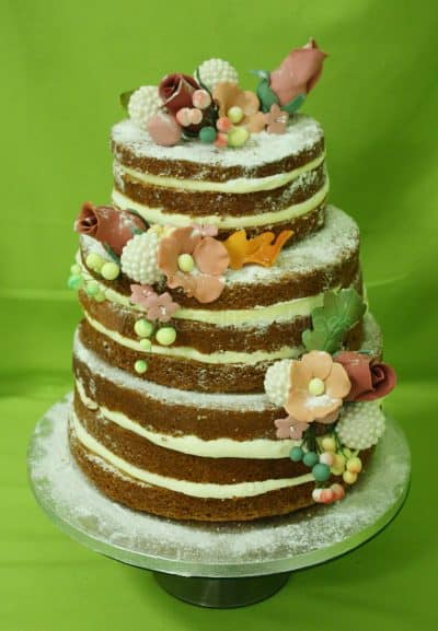 Tarta desnuda de tres pisos decorada con flores talladas en fondant.