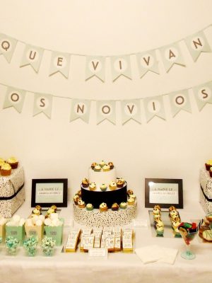 Mesa dilce compuesta por cupcakes de sabor limon, minicupcakes sabor vainilla, donuts con glaseado en color blanco y chocolate, pequeños pastelitos, cake pops cubiertos de candy mels azul y chocolate, pequeños vasitos con palomitas de colores, galletas de mantequilla rectangulares decoradas con papel de azúcar comestible, y diferentes tipos de gominola