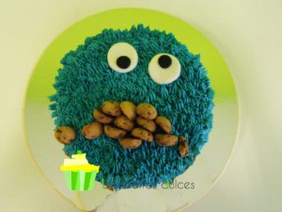 Tarta cubierta de buttercream de vainilla de color azul, decorada con unos ojos de fondant y galletas.