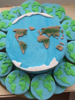 Tarta forrada de fondant con decoracion de fondant recreando el mapa mundi. Galletas de mantequilla, decoradas con fondant y glaseado real recreando el mapa mundi.