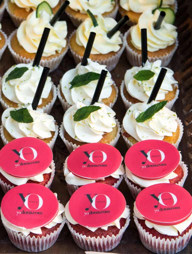 Cupcakes red velvet, decorados con buttercream de vainilla y el logotipo de la empresa "Yo dona"en papel de azúcar, cupcakes de vainilla con buttercream sabar mojito decorados pajita, y una hoja de hierbabuena