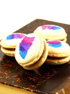 macaron color crema con relleno de dulce de leche y decorado con pintura comestible